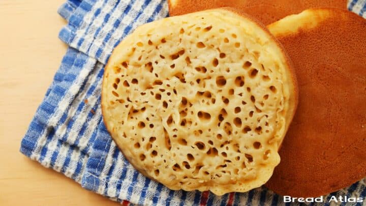 Crumpets placed on a kitchen towel.