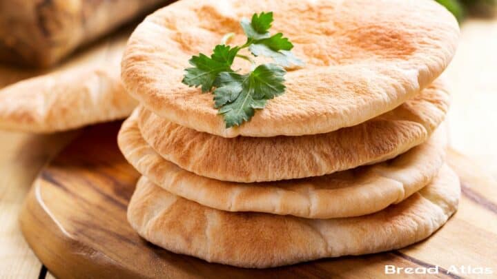 A stack of pita bread on a wooden surface.